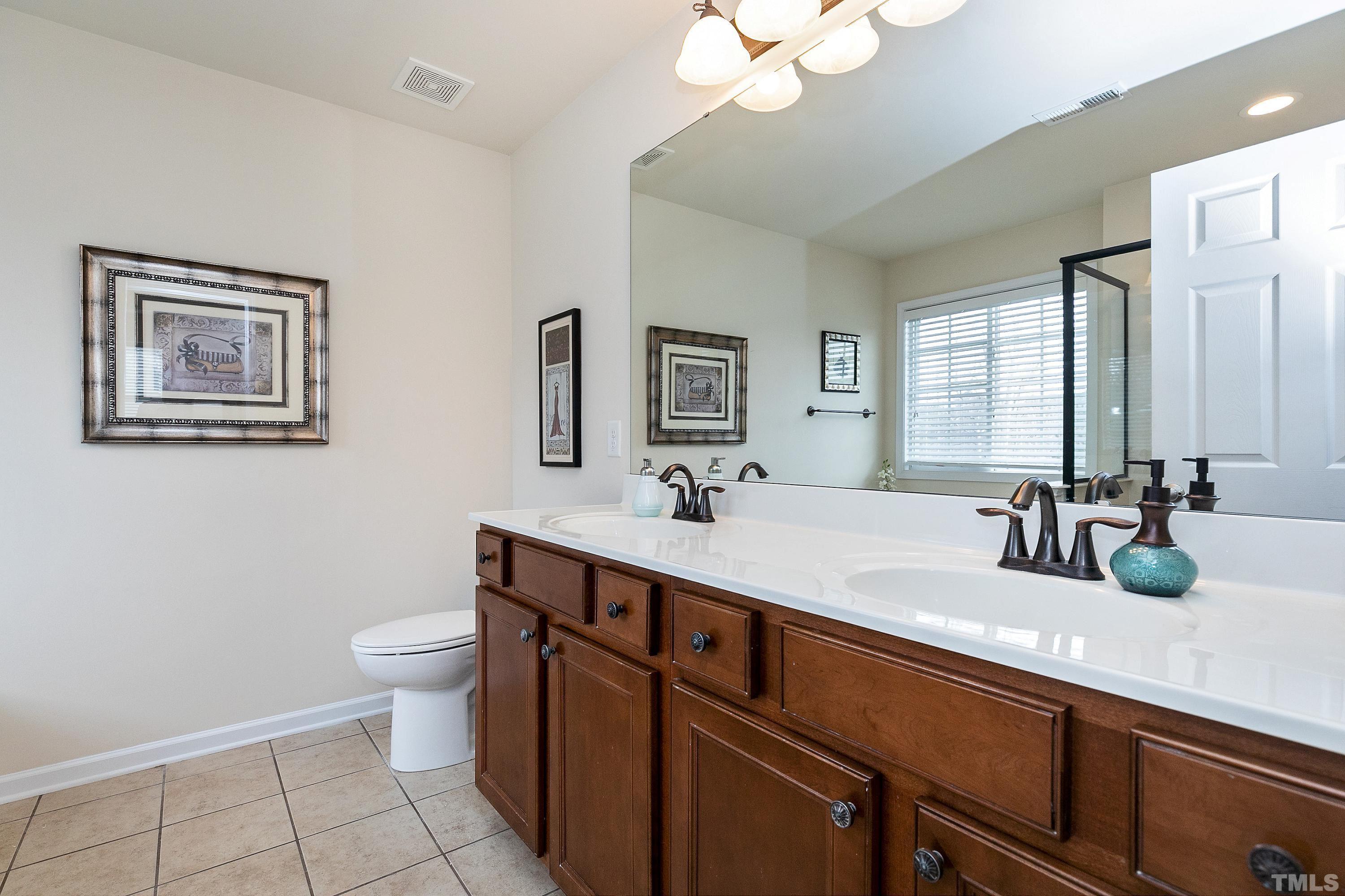 891 Seastone Street Raleigh, NC 27603 - Photo 21 of 51 a bathroom with a double vanity sink mirror and toilet