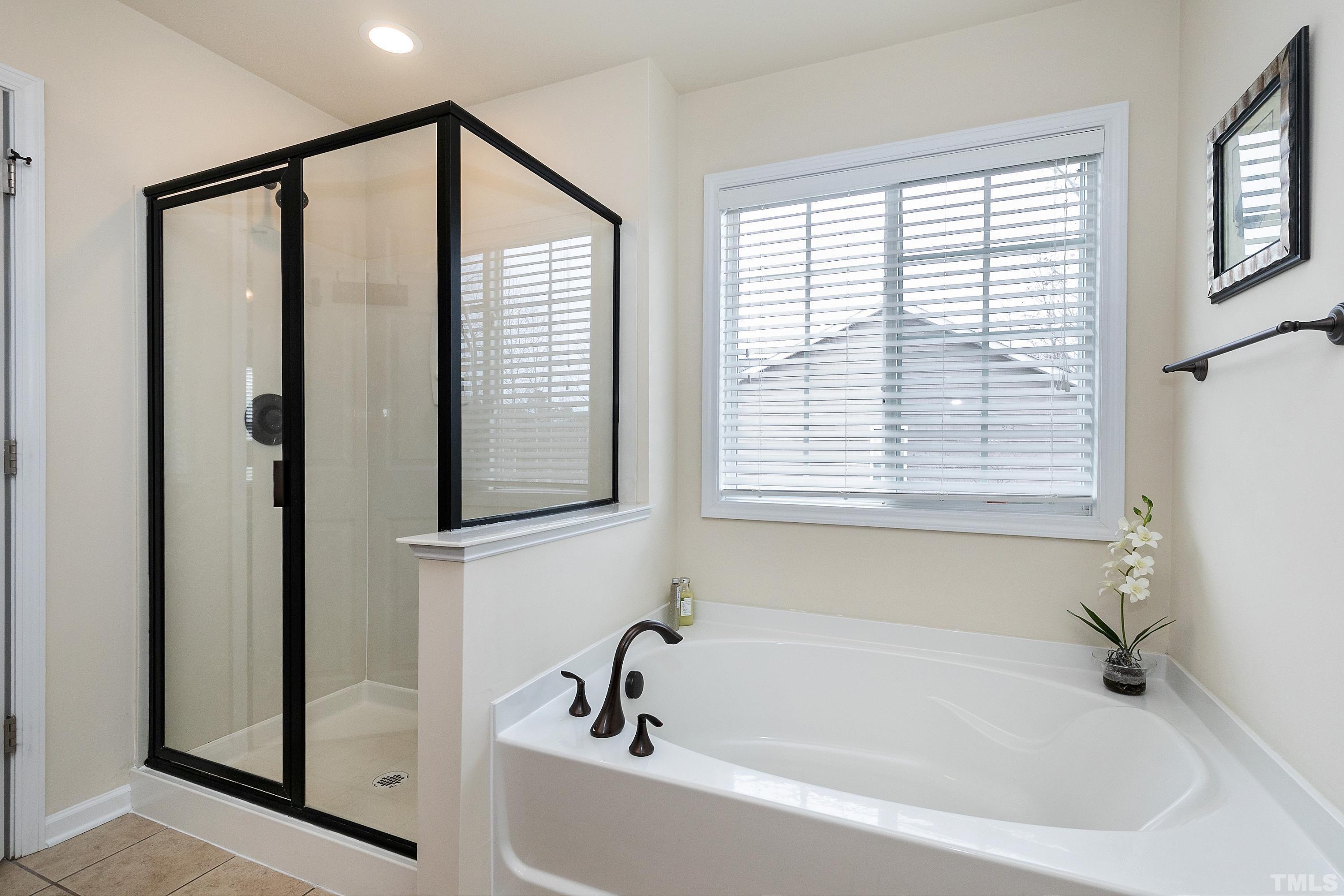 891 Seastone Street Raleigh, NC 27603 - Photo 22 of 51 a bathroom with a bathtub and a shower