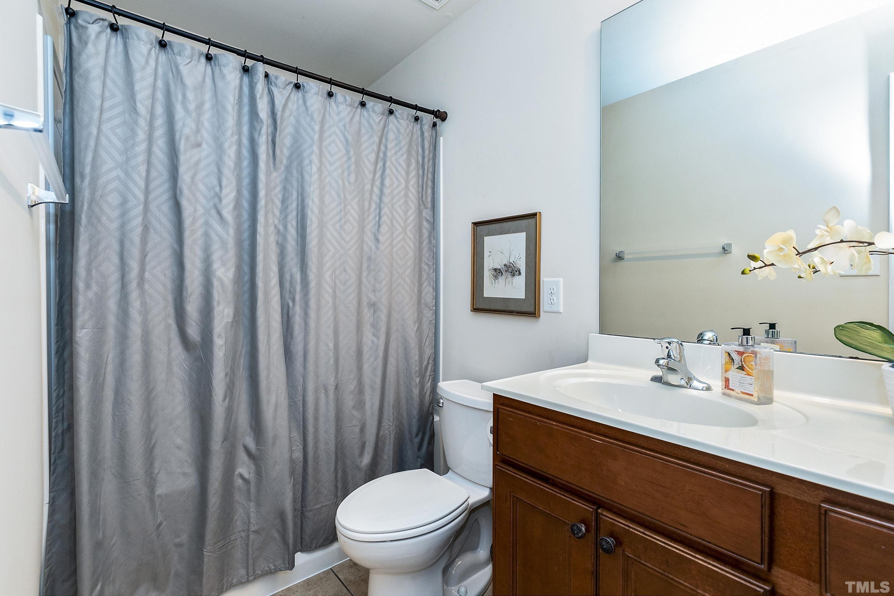 891 Seastone Street Raleigh, NC 27603 - Photo 27 of 51 a bathroom with a sink a toilet and shower curtain