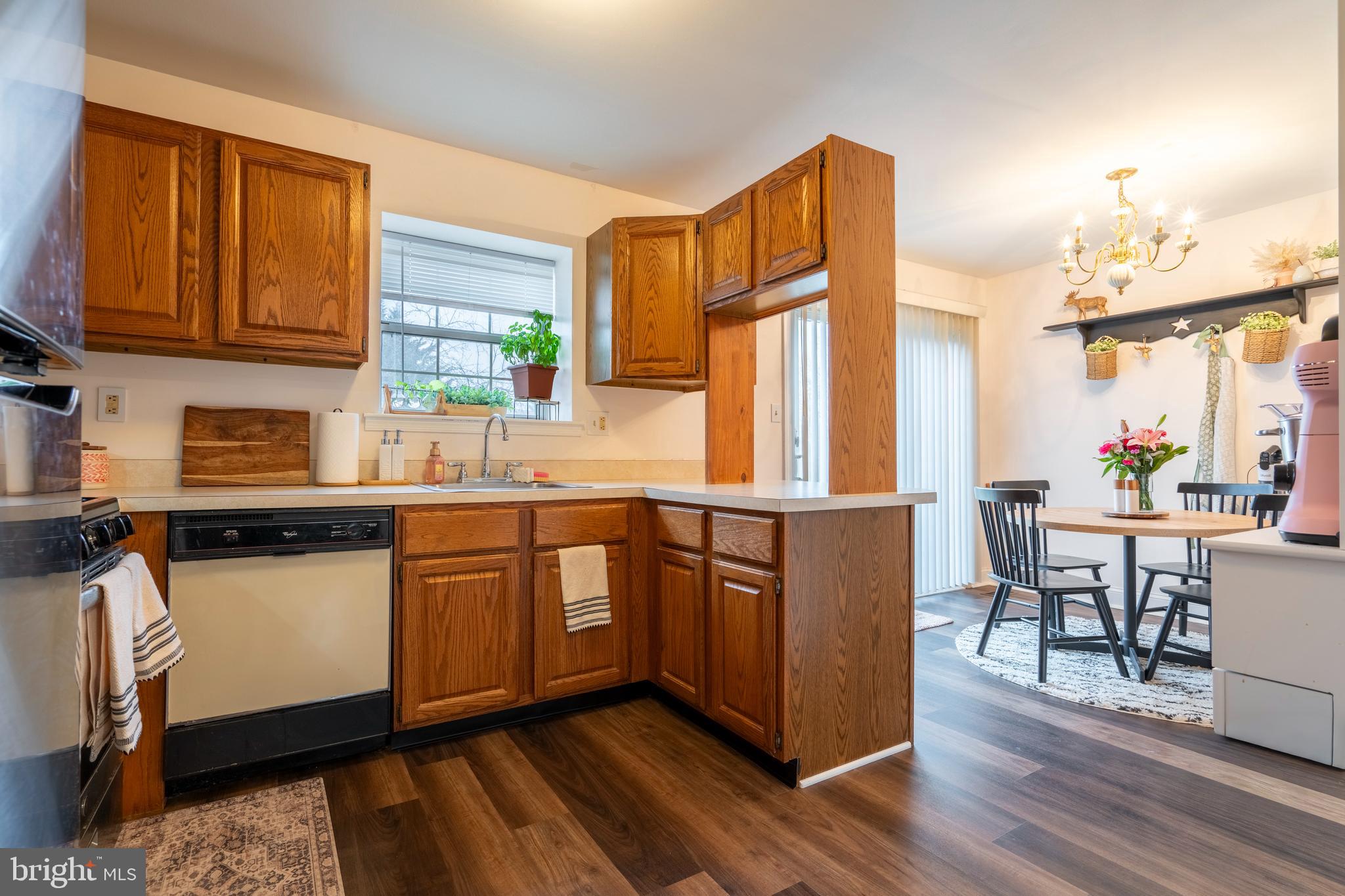1410 Sentry Lane Eagleville, PA 19403 - Photo 11 of 32 a kitchen with stainless steel appliances granite countertop wooden cabinets a dining table and chairs