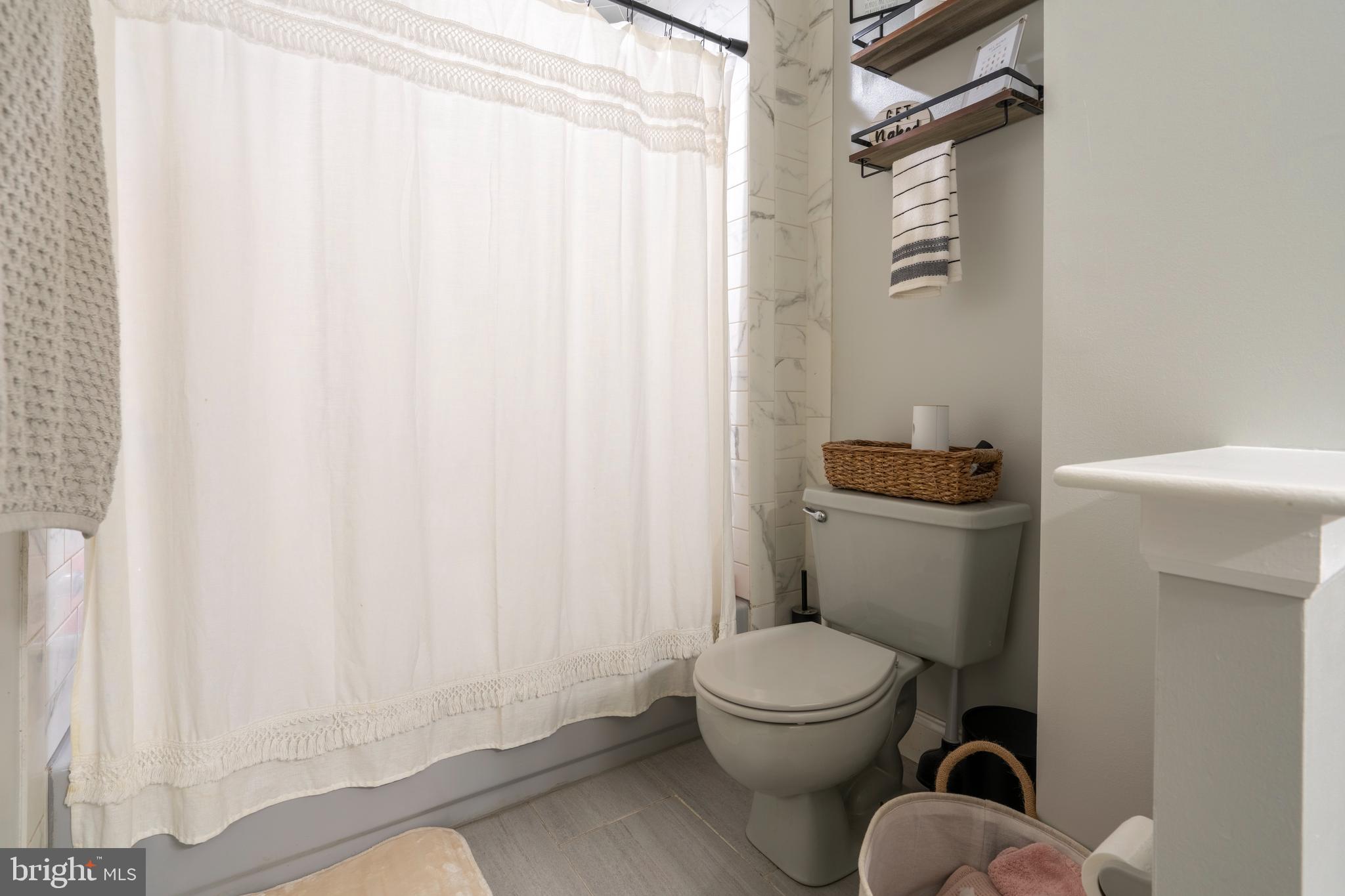 1410 Sentry Lane Eagleville, PA 19403 - Photo 21 of 32 a white toilet sitting next to a shower curtain