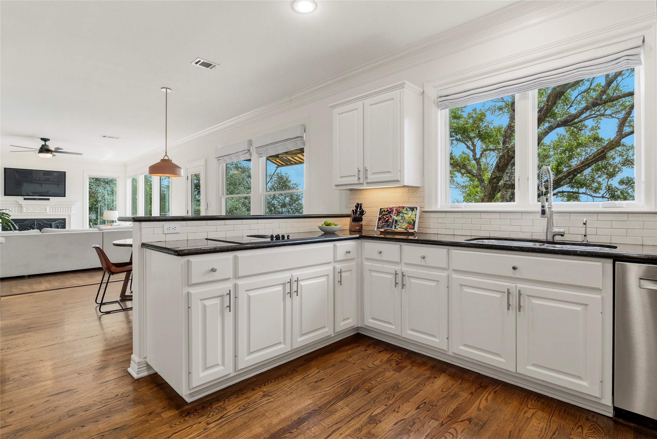 3107 Lookout Lane Austin, TX 78746 - Photo 18 of 39 Granite counters and subway tile backsplash complete this well-lit kitchen with views to the outdoors.