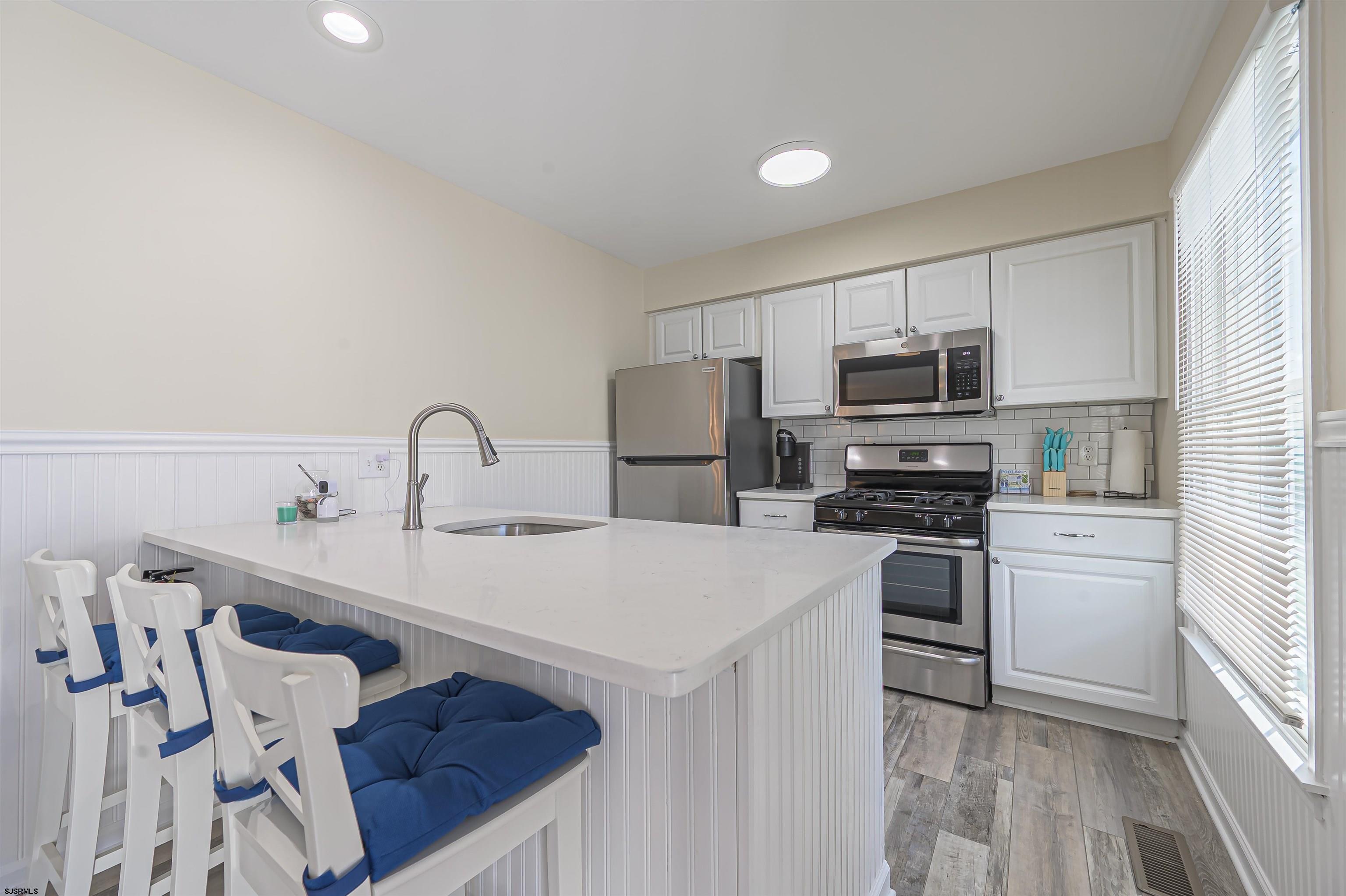 162 39th Street South, Unit 162 Brigantine, NJ 08203 - Photo 6 of 16 a kitchen with stainless steel appliances a sink a stove a refrigerator cabinets and a window