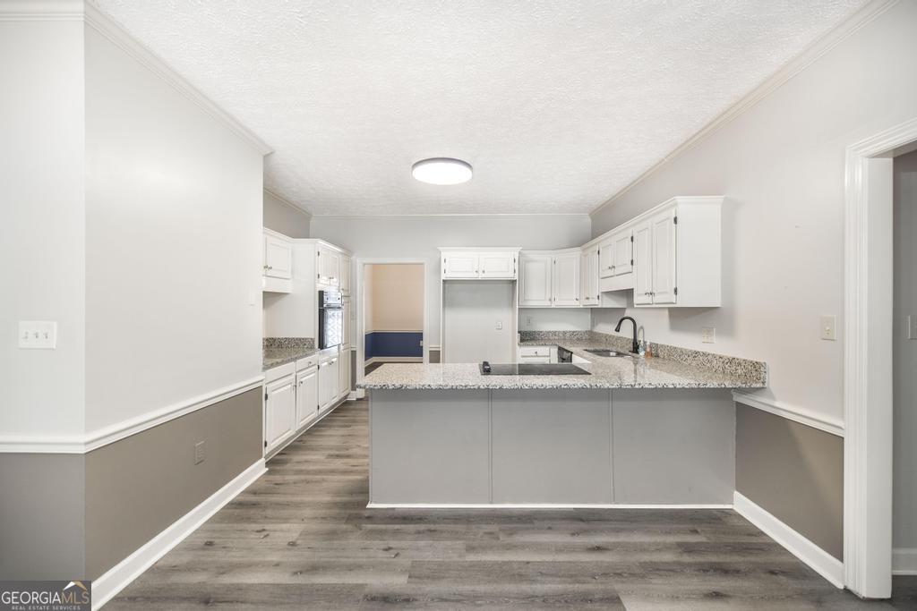 3077 River Ridge Drive Macon, GA 31204 - Photo 14 of 35 a large white kitchen with a sink and dishwasher with wooden floor
