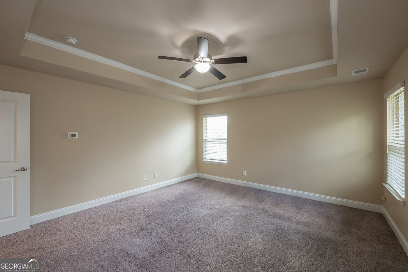 12172 Flannery Lane Hampton, GA 30228 - Photo 20 of 31 en empty room with windows and ceiling fan