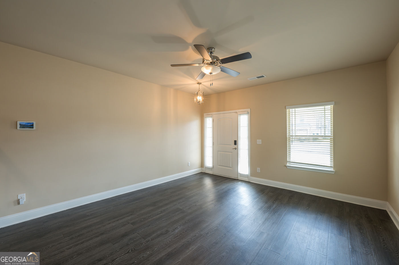 12172 Flannery Lane Hampton, GA 30228 - Photo 6 of 31 an empty room with wooden floor and windows
