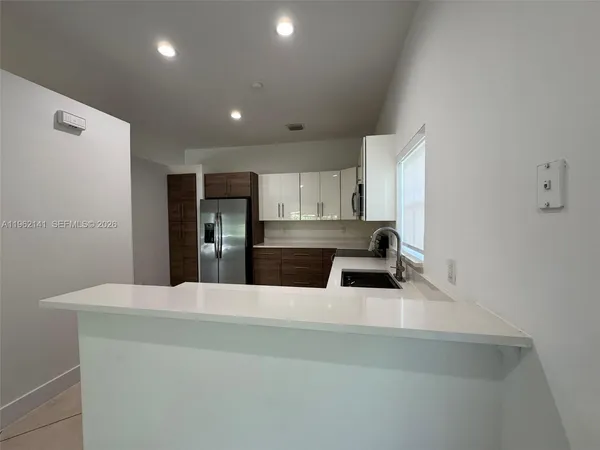 a kitchen with a sink a counter top space cabinets and stainless steel appliances