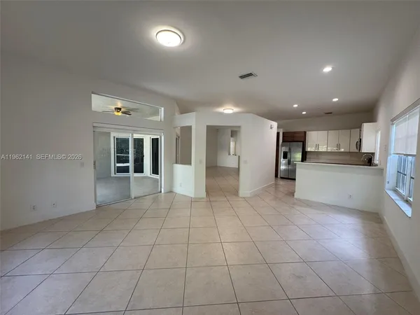 a view of a electric appliances in kitchen and an empty room