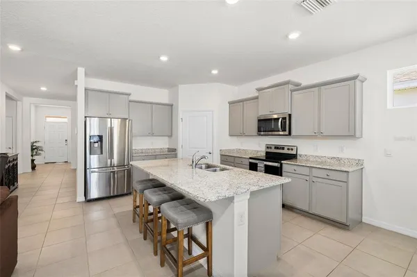 a kitchen with a refrigerator a stove top oven and a sink