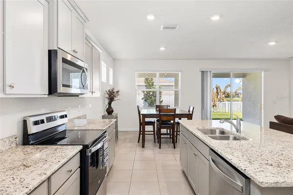 a kitchen with granite countertop stainless steel appliances cabinets a sink and a counter top space