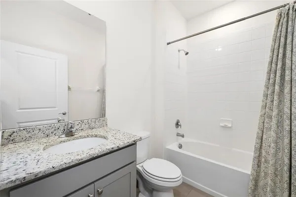 a bathroom with a granite countertop sink a toilet and shower
