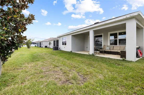a view of a house with a big yard and potted plants
