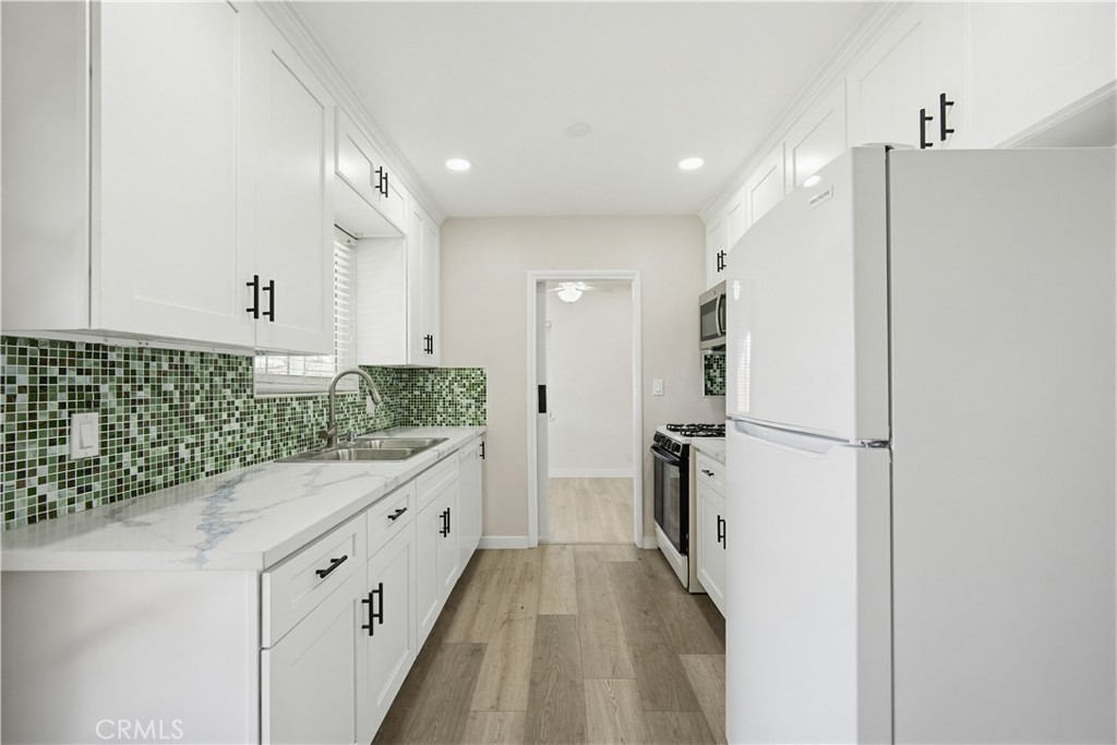9805 Devon Street Rancho Cucamonga, CA 91730 - Photo 13 of 31 a kitchen with white cabinets and refrigerator