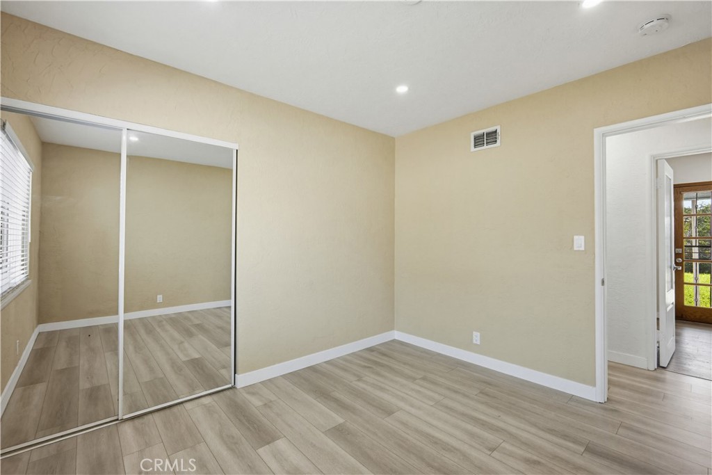 9805 Devon Street Rancho Cucamonga, CA 91730 - Photo 16 of 31 an empty room with wooden floor and closet area