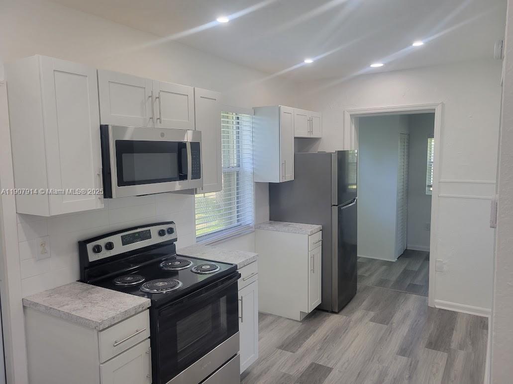 751 Northwest 96th Street Miami, FL 33150 - Photo 6 of 12 a kitchen with a stove and a refrigerator