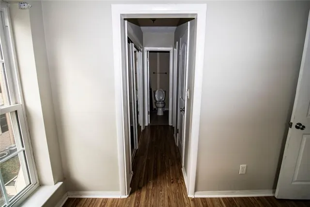a view of a hallway with wooden floor and a cabinet