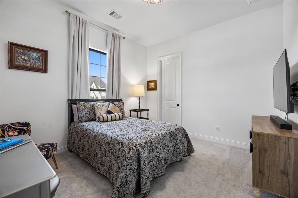 1717 Tolleson Drive Fort Worth, TX 76008 - Photo 21 of 40 a bedroom with a bed and a flat screen tv