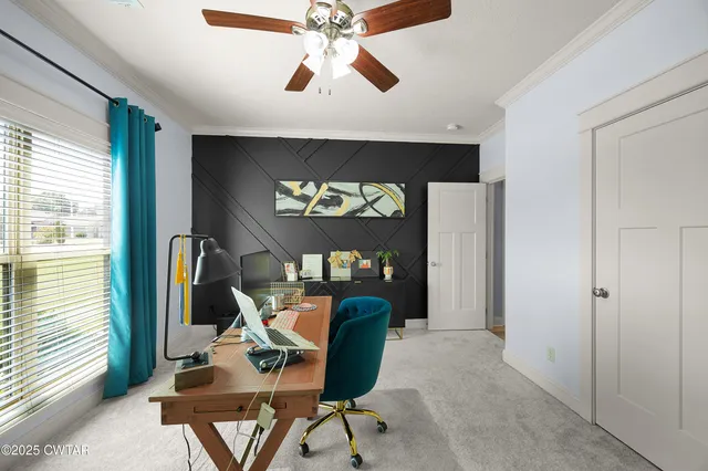 a view of a workspace with furniture and a window