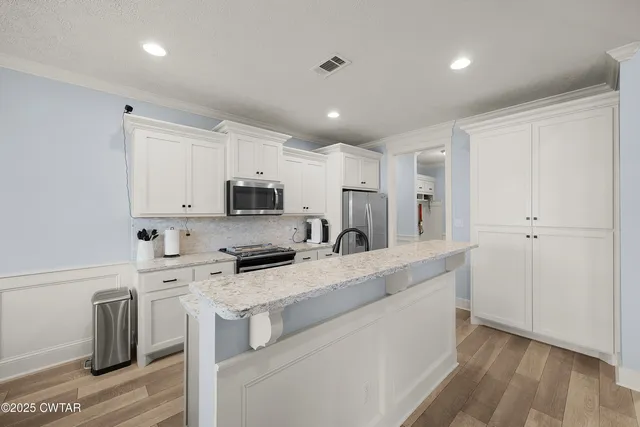 a kitchen with stainless steel appliances a refrigerator sink and microwave