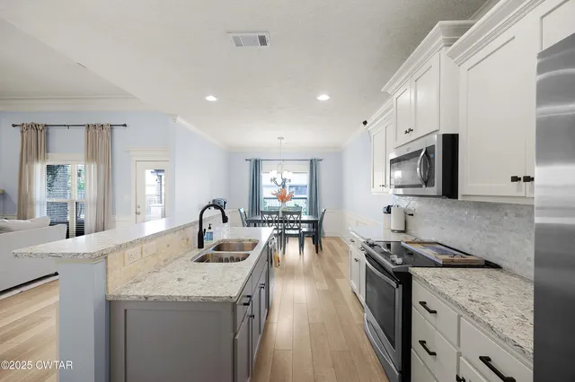 a kitchen with granite countertop a sink stove and cabinets