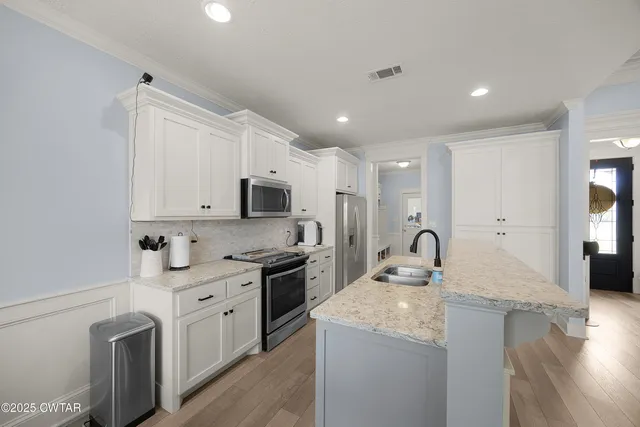 a kitchen with stainless steel appliances granite countertop a sink stove and refrigerator