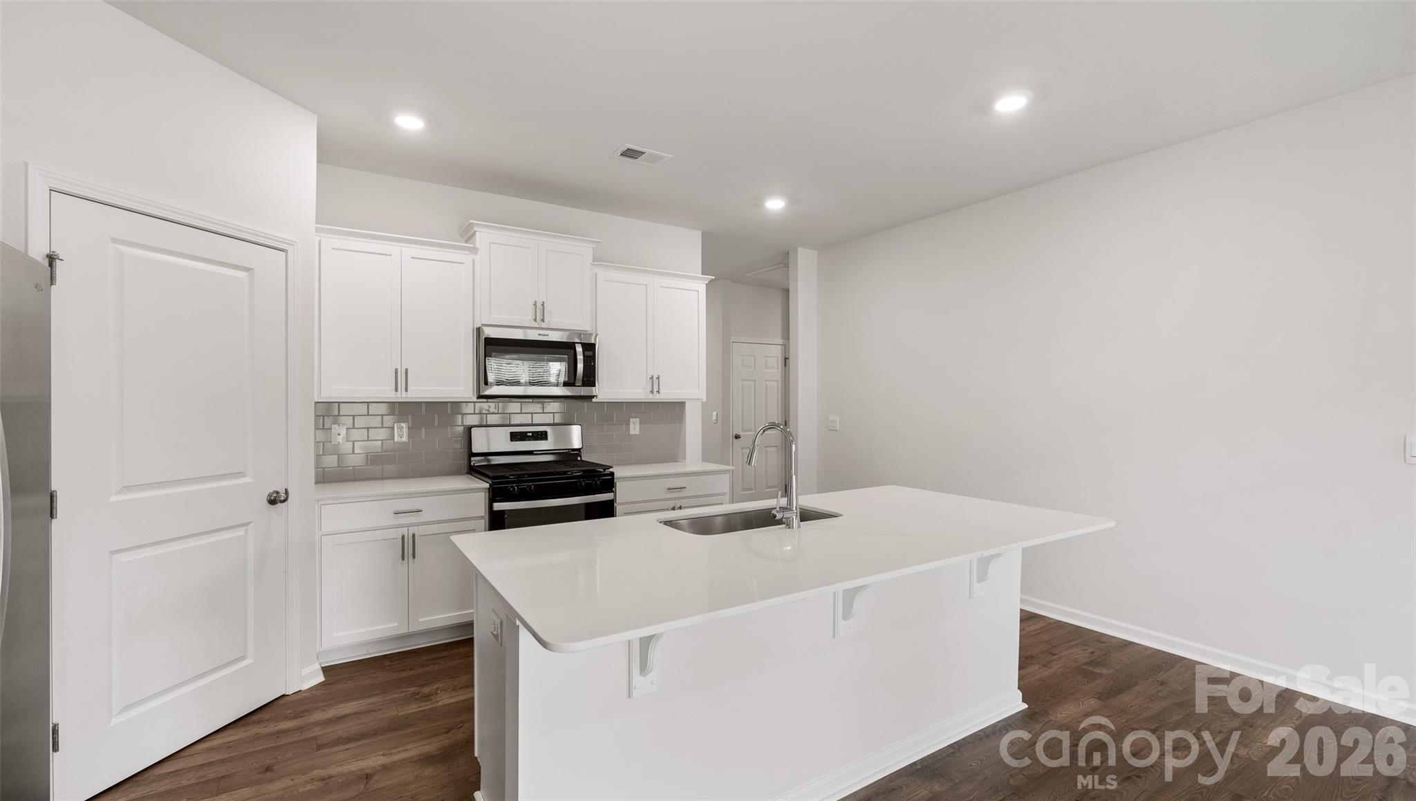 100 Piney Wds Road Fletcher, NC 28732 - Photo 9 of 33 a kitchen with a sink a microwave a stove and refrigerator