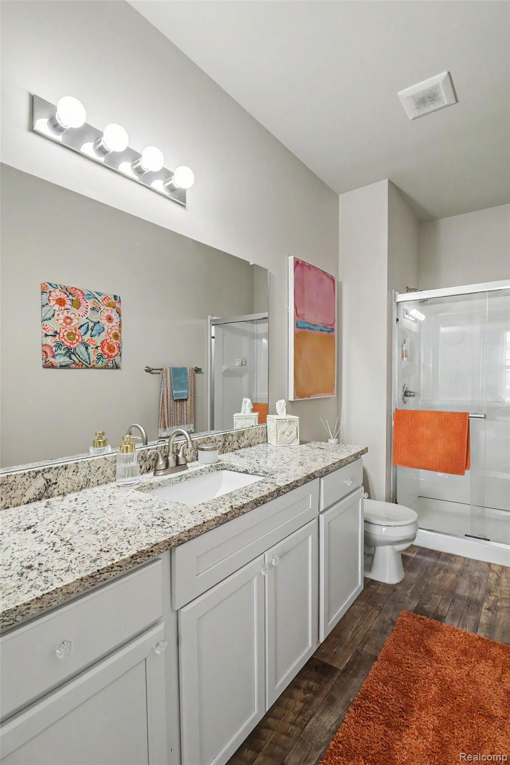 9864 Ridge Run Street Howell, MI 48855 - Photo 17 of 23 Full bath with a shower stall, vanity, and dark wood-style floors