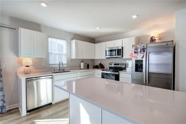a kitchen with a refrigerator a sink a stove a microwave and cabinets