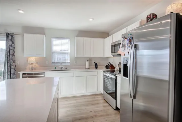 a kitchen with a refrigerator sink and cabinets