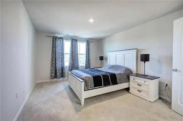 a spacious bedroom with a bed and a window