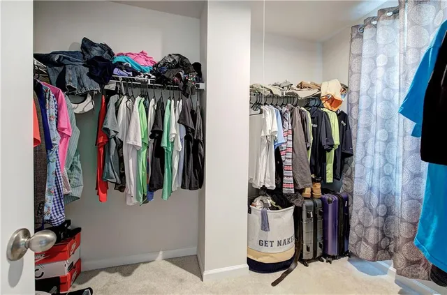 a view of walk in closet with clothes