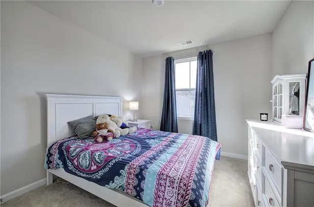 a bedroom with a large bed and a chandelier