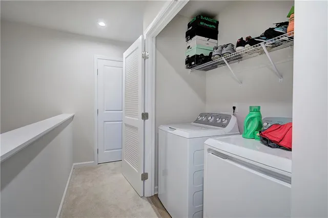 a view of storage and utility room with dryer and washer
