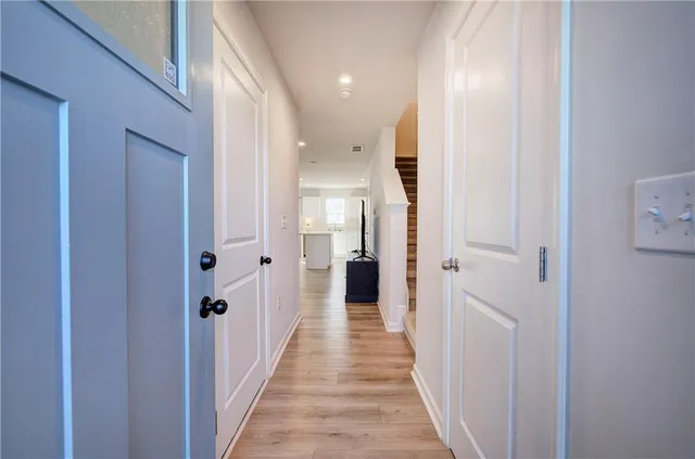 a view of a hallway with wooden floor and closet