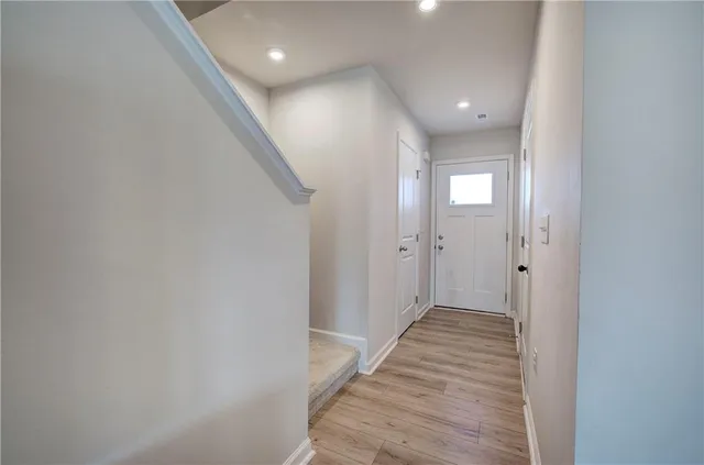 a view of a hallway with wooden floor and staircase