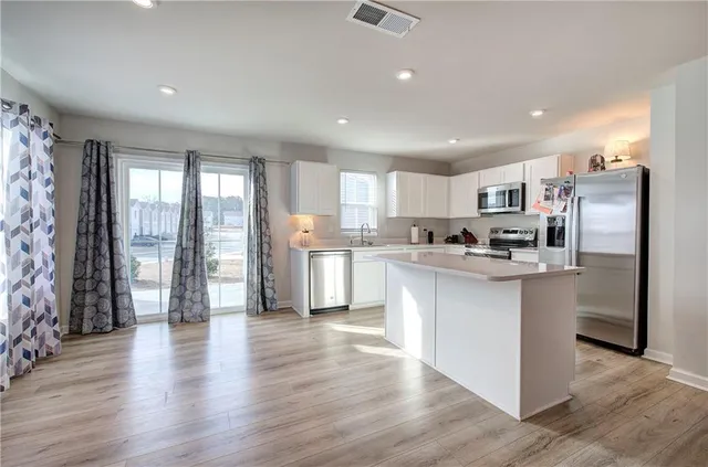 a kitchen with stainless steel appliances granite countertop a refrigerator and a sink