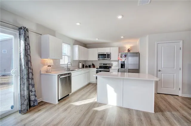 a kitchen with white cabinets and stainless steel appliances
