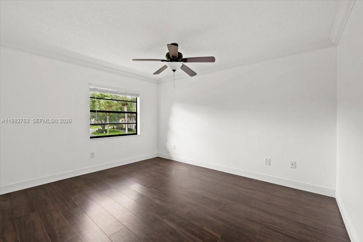 7944 Eastlake Drive, Unit D Boca Raton, FL 33433 - Photo 20 of 29 an empty room with wooden floor ceiling fan and windows