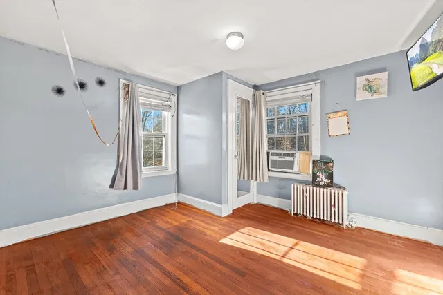 a view of a livingroom with wooden floor and a window