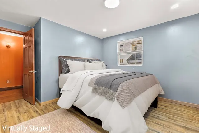 a bedroom with a bed and wooden floor