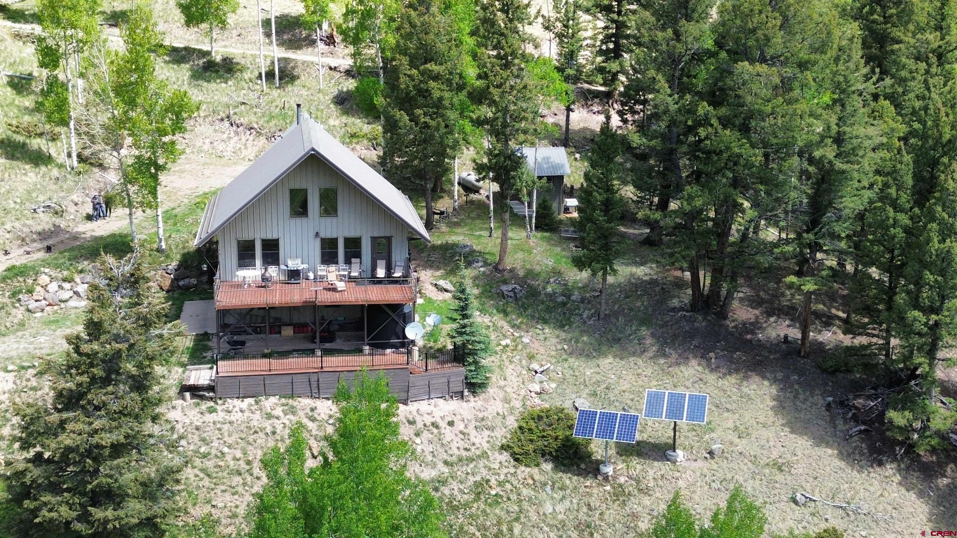 1113 Spring Street Del Norte, CO 81132 - Photo 9 of 43 an aerial view of a house with swimming pool and large trees
