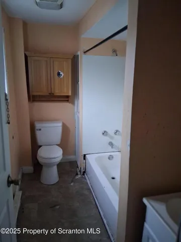 a white toilet sitting next to a bathroom sink