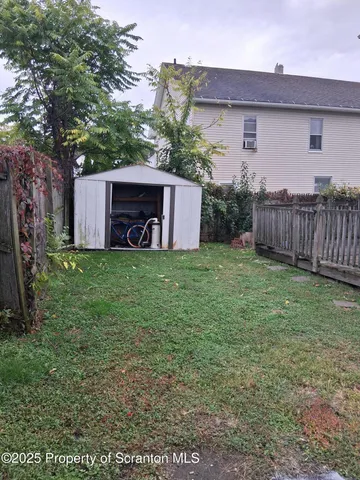 a view of a house with a yard and fence
