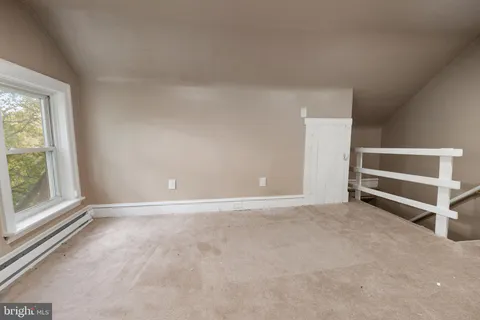 an empty room with a fireplace and windows