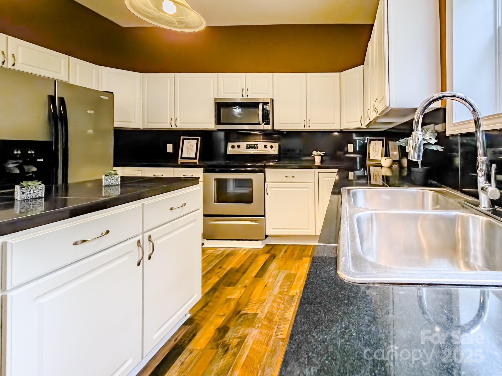 883 Pinehurst Road Ellenboro, NC 28040 - Photo 4 of 47 a kitchen with stainless steel appliances granite countertop a sink a stove and a microwave