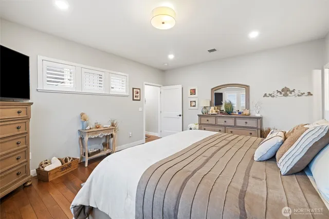 a bedroom with a bed and a flat tv screen on dresser