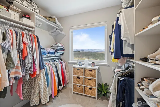 a view of walk in closet with clothes and shoes