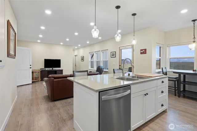 a kitchen with stainless steel appliances kitchen island granite countertop a sink a stove and a large mirror