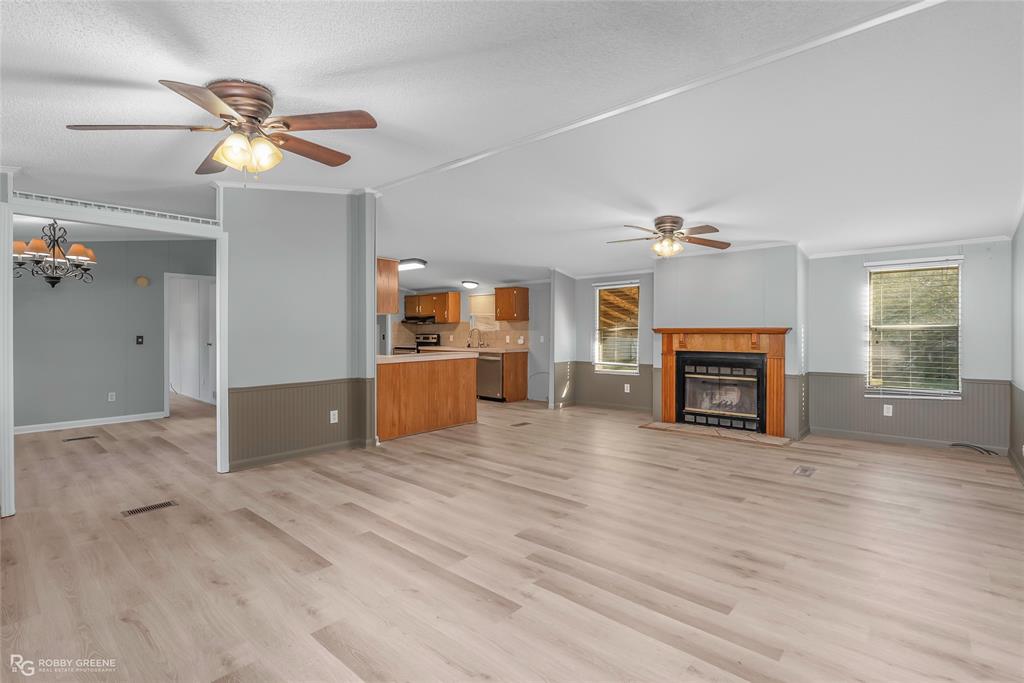 121 Kim Circle Stonewall, LA 71078 - Photo 9 of 33 a view of a livingroom with a fireplace a ceiling fan and wooden floor