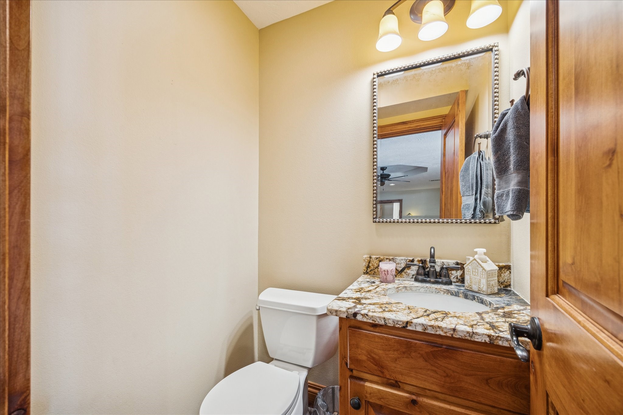 640 Piney Creek Road Bellville, TX 77418 - Photo 12 of 35 a bathroom with a granite countertop toilet sink and mirror